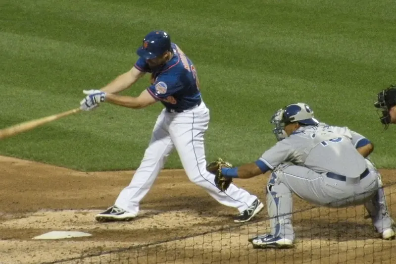 A catcher sets up behind home plate to receive the pitch
